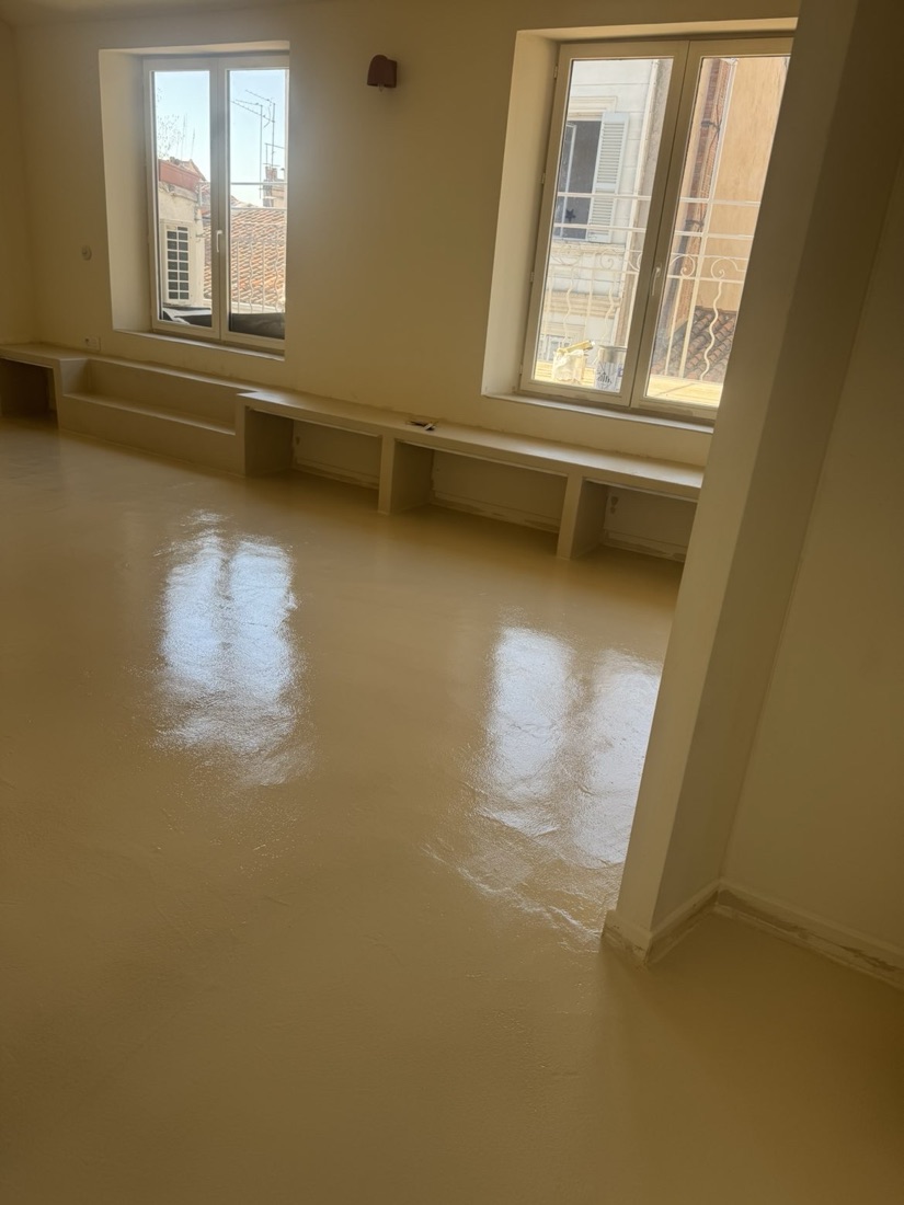 Séjour rénové avec sol béton ciré clair et grandes ouvertures